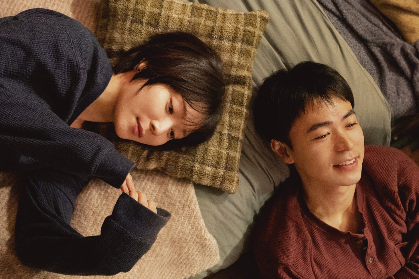 映画『男ともだち』の一場面。クッションに頭をあずけた神名と、隣で笑いかけるハセオ