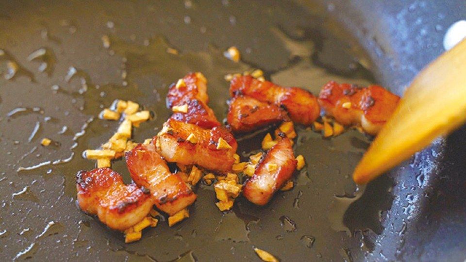 フライパンでベーコンとにんにくを炒めているところ