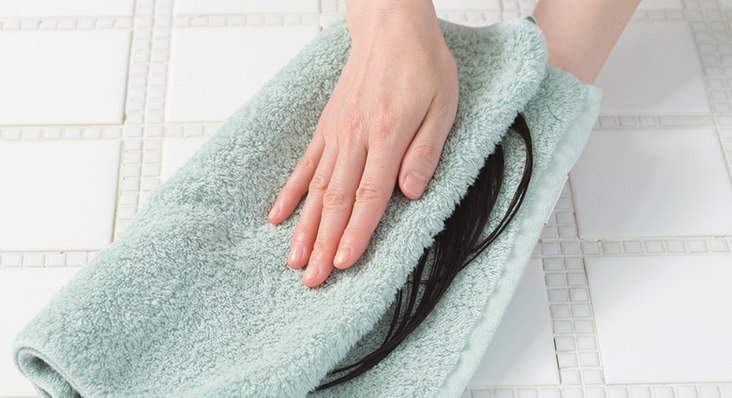タオルでウィッグを包み水分を取っている様子