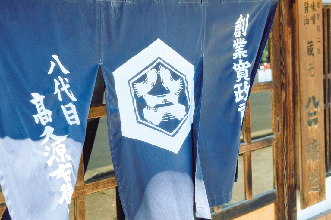 「八代目 高久源右衛門」と染め抜かれた藍色ののれん
